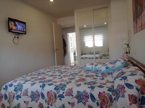 um quarto com uma cama com um edredão colorido em CUATRO CAMINOS em Zamora