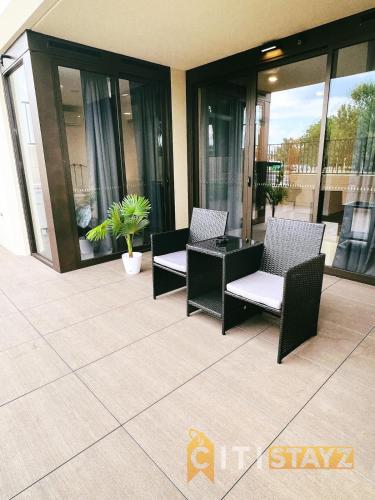 a patio with two chairs and a table on a balcony at Contemporary in Kingston-2bd Apt in Kingston 