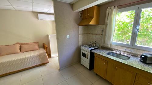 uma cozinha com uma cama e um lavatório num quarto em Alojamiento Coihueco em Malargüe