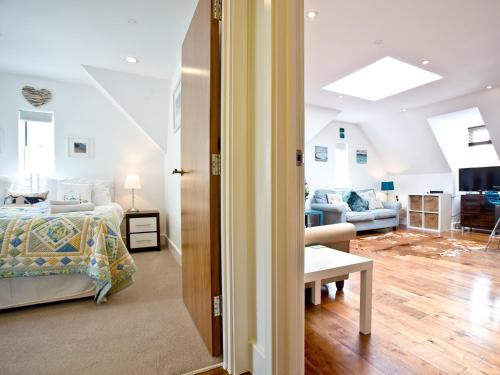 a bedroom with a bed and a living room at 9 The Whitehouse in Mawgan Porth