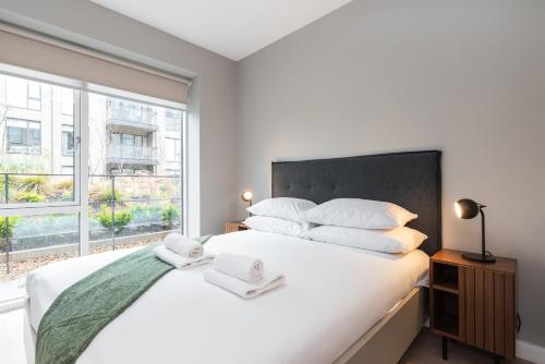 Schlafzimmer mit einem großen weißen Bett und einem Fenster in der Unterkunft Woodward Square in Dublin
