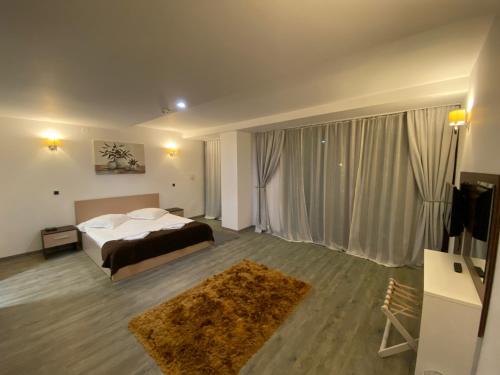 a bedroom with a bed and a large window at Silver Mountain Apartment in Poiana Brasov