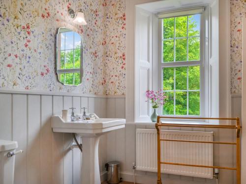 baño con lavabo y ventana en Monkwood Cottage en Hale