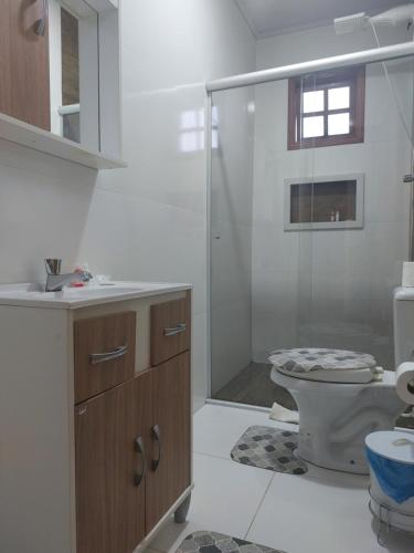uma casa de banho com um WC e uma cabina de duche em vidro. em H&C Pousada em São Gabriel