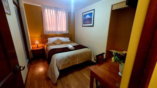 Habitación pequeña con cama y ventana en Andes Colca Hostal, en Chivay