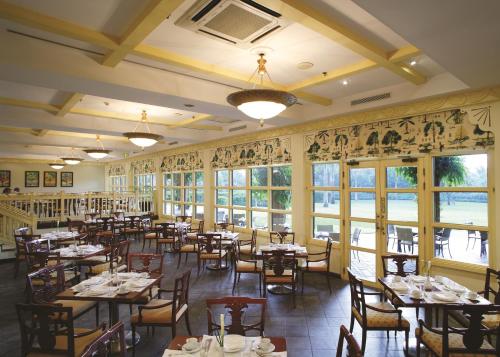 a dining room with tables and chairs and windows at Dar es Salaam Serena Hotel in Dar es Salaam