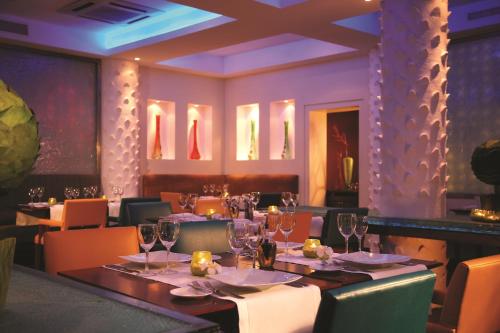 a dining room with tables and chairs with wine glasses at Dar es Salaam Serena Hotel in Dar es Salaam
