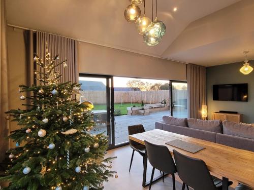 un árbol de Navidad en una sala de estar con mesa en Blue Iris Cottage, Ashlin Farm Barns en Lincoln