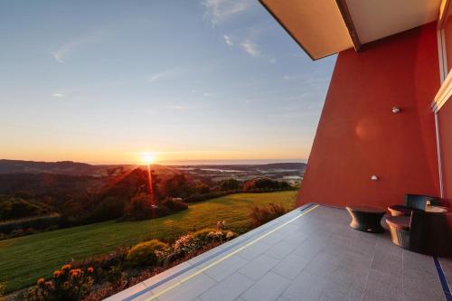 a view from the balcony of a house with the sunset at Mt Hay Retreat in Berry