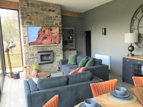 a living room with two couches and a stone fireplace at Yorkshire Dales Lodge 10 by Together Travel - 3-Bed Ensuite Retreat in Richmond