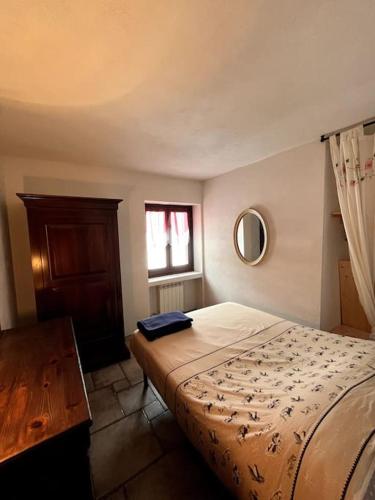 a bedroom with a bed and a table and a window at Appartamento-Grangesises in Grange Sises