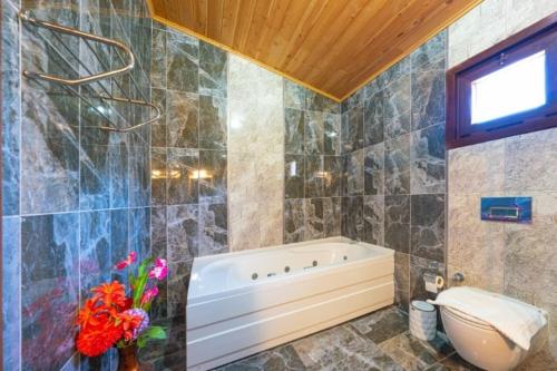 a bathroom with a tub and a toilet at Kaya Koy Deluxe Villas Fethiye in Fethiye