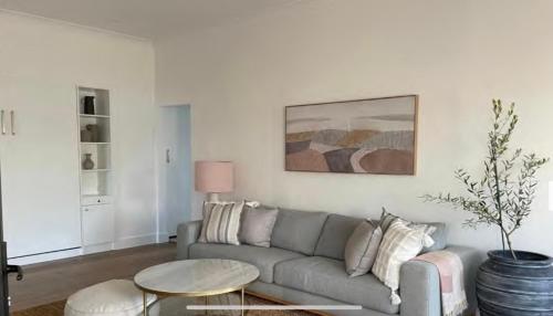 a living room with a couch and a table at 4BR Waterfront - Skippers Quarterdeck in Lakes Entrance
