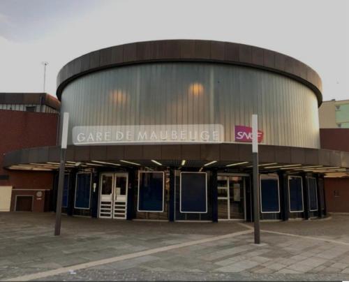 a large building with a sign that reads garage de mauldinian at Studio confort #2, proche Gare et commodités in Maubeuge