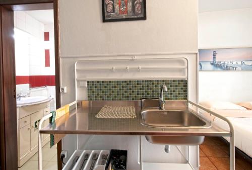a kitchen with a sink and a counter top at Ribeira Smart Suite in Porto
