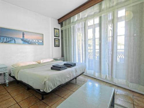 a bedroom with a bed and a large window at Ribeira Smart Suite in Porto