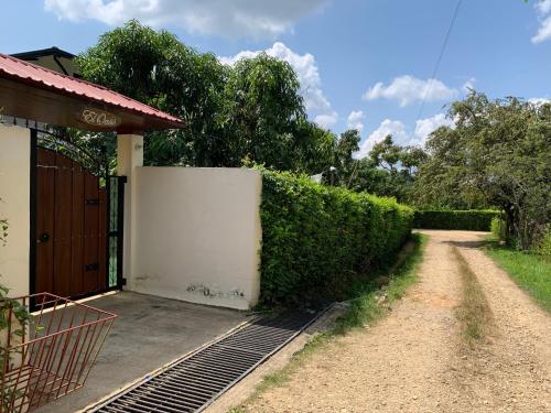 a driveway leading to a house with a fence at Acogedora cabaña, naturaleza, familia - NUEVA - ANAPOIMA in Anapoima