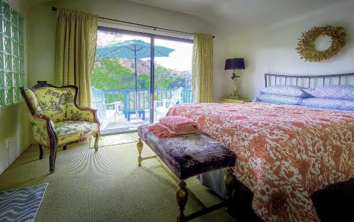 a bedroom with a bed and a chair and a window at Rio Sierra Riverhouse in Three Rivers
