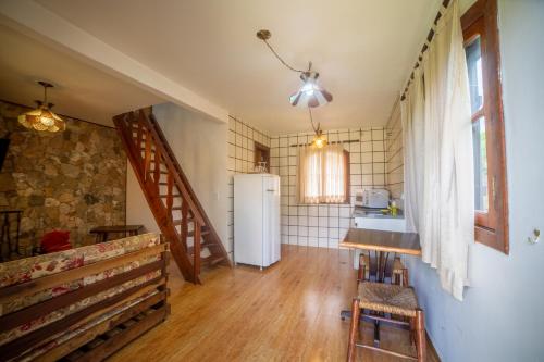a kitchen with a sink and a refrigerator at Pousada das Pedras in Monte Verde