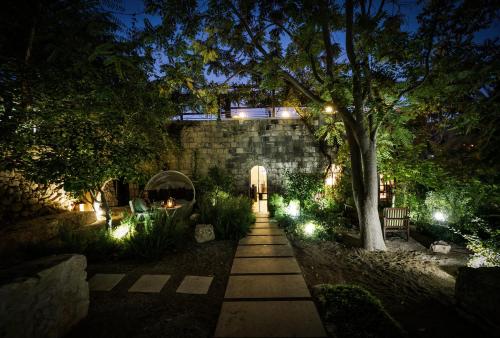 a walkway in a garden at night with lights at Alegra Boutique Hotel in Jerusalem