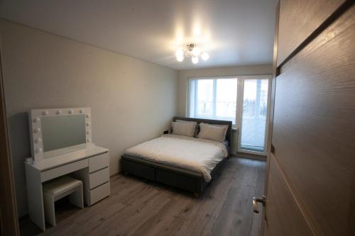niewielka sypialnia z łóżkiem i oknem w obiekcie Maya's Apartment w Wilnie