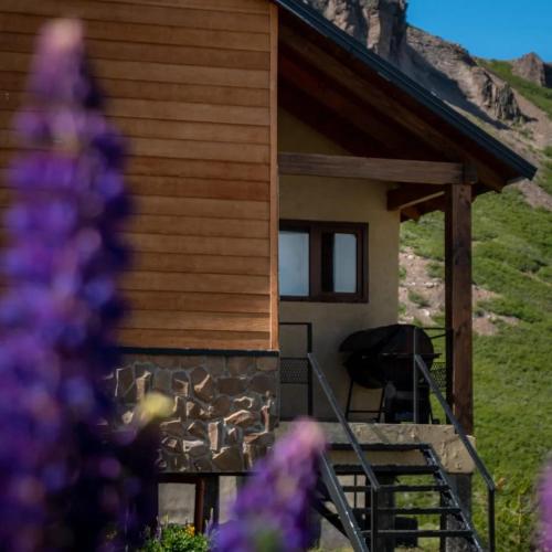 a log cabin with a chair on the porch at PEWMA Casa de Montaña in Caviahue