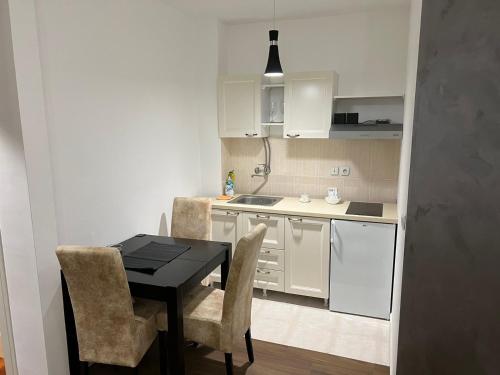 a small kitchen with a black table and chairs at Apartman Castor in Vrnjačka Banja
