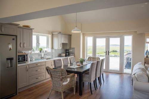 a kitchen with a table with chairs and a dining room at Paddy Carrolls Cottage in Ballyconneely