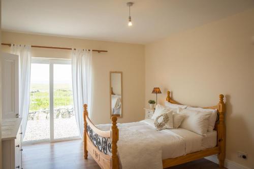 a bedroom with a bed with a view of the ocean at Paddy Carrolls Cottage in Ballyconneely
