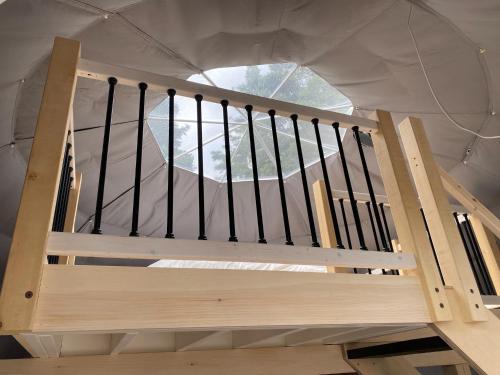 a wooden staircase in a tent with a window at Domes Rocher Percé at Domaine Renard in Perce