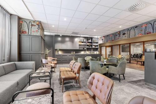 a waiting room with couches and tables and chairs at Best Western Plus Savoy Lulea in Luleå