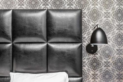 a leather headboard with a lamp and a chair at Best Western Plus Savoy Lulea in Luleå