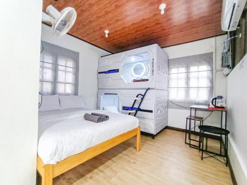 ゲンティンハイランドにあるGenting Greenwoods Tiny Houses & Events Hallの白い大型ベッドが備わる客室です。
