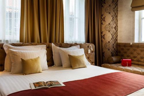 a bedroom with a bed with a book on it at Gallery 37 Powered by ASTON in Plovdiv