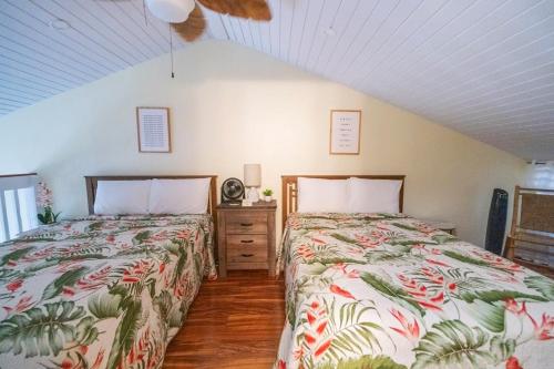dos camas sentadas una al lado de la otra en un dormitorio en Aloha Nui Loa, en Kahuku