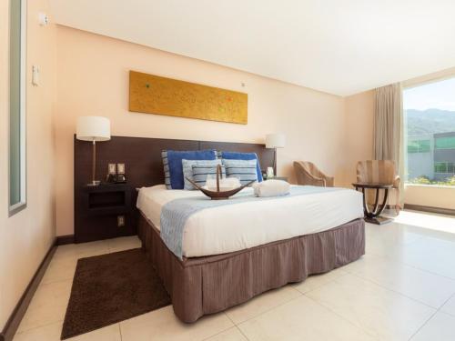 a bedroom with a large bed and a large window at Studio Hotel Boutique in San José