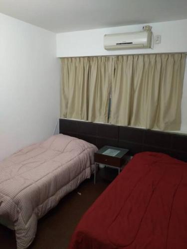 Cette chambre dispose de deux lits et d'une fenêtre avec chauffage. dans l'établissement Comodo departamento en San Nicolas, à Buenos Aires