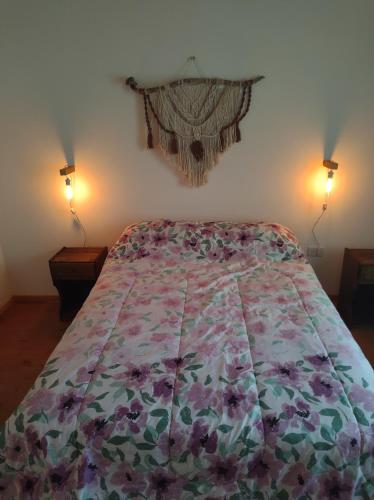 a bedroom with a bed with a floral bedspread at Alojamientos Rossi in Malargüe