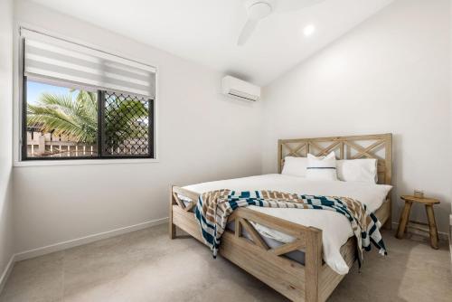 a white bedroom with a bed and a window at 7 bedroom home on Mooloolaba canal in Mooloolaba
