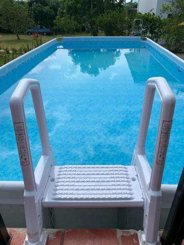 a chair sitting in front of a swimming pool at Acogedora cabaña, naturaleza, familia - NUEVA - ANAPOIMA in Anapoima