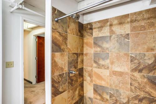 a bathroom with a shower with a stone wall at Centric Modern Loft w/ King Beds & Smart GameTable in Rochester