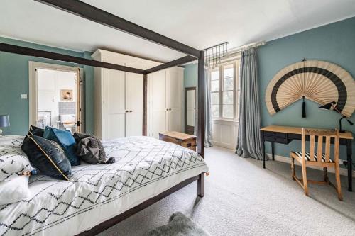 een slaapkamer met een groot bed en een bureau bij Bressingham Lodge - Norfolk Holiday Properties in Diss