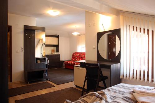 a room with a bed and a desk with a mirror at Guest House Koncheto in Bansko