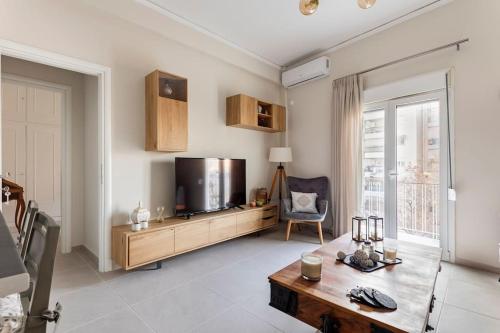 una sala de estar con un televisor y una mesa en Acropolis View, en Atenas