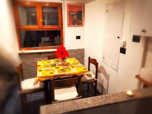 una mesa y sillas en una cocina con una mesa y flores. en Kintsugi Loft en Turín