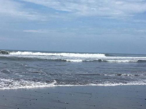 a beach with some waves in the ocean at Nuestro Castillo, Playa San Blas, La Libertad, El Salvador in La Libertad