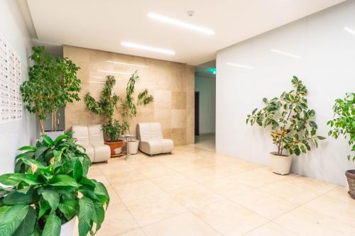 un hall de bureau avec des plantes sur les murs dans l'établissement Opal Luxury Aviatiei, à Bucarest