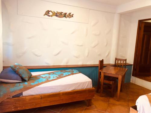 a bedroom with a bed and a wooden table at Playa Bluff Lodge in Bocas del Toro