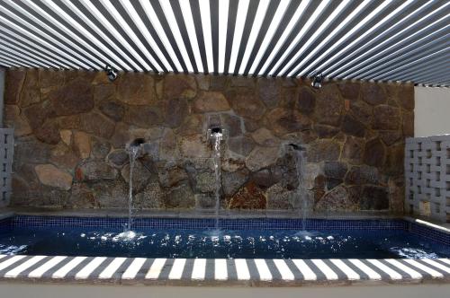 a pool with two water fountains and a stone wall at Casa 1810 Hotel Boutique in San Miguel de Allende