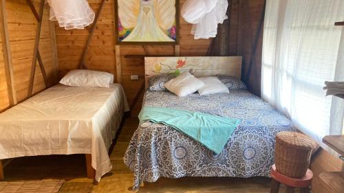 Habitación pequeña con cama y ventana en Arcoiris Casahostal, en San Bernardo del Viento